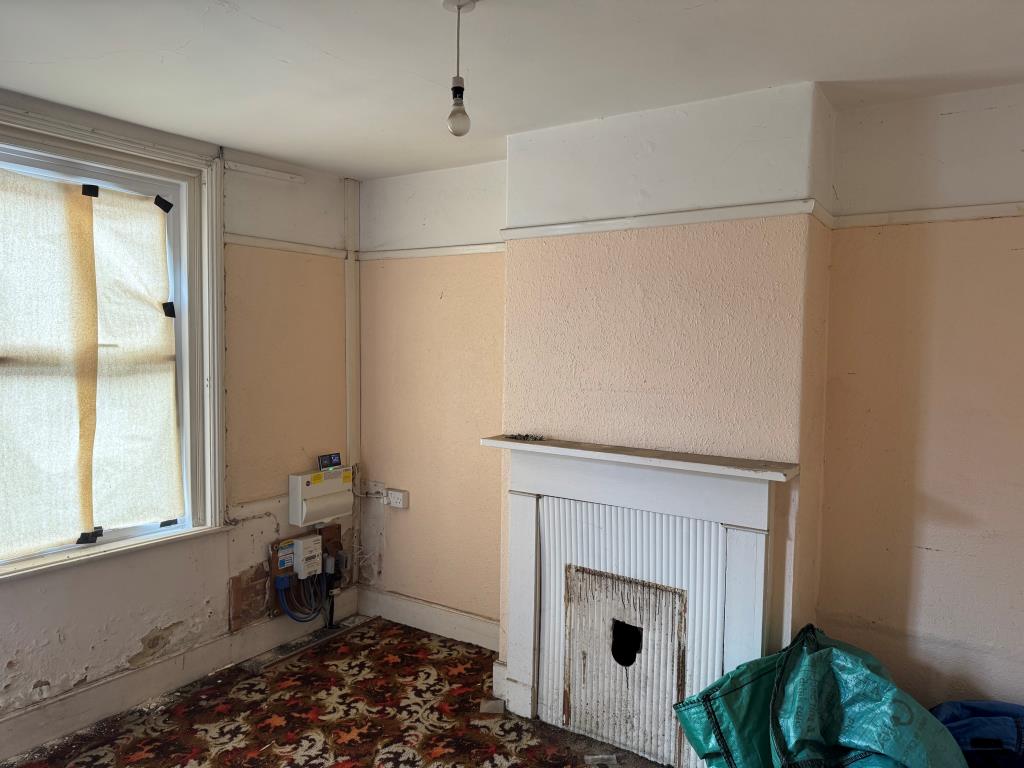 Lot: 133 - FREEHOLD TOWN CENTRE HOUSE FOR IMPROVEMENT - Living room with fireplace and electric meter